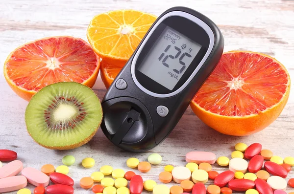 Glucometro con risultato, frutta e pillole mediche colorate, diabete, stile di vita sano e nutrizione — Foto Stock