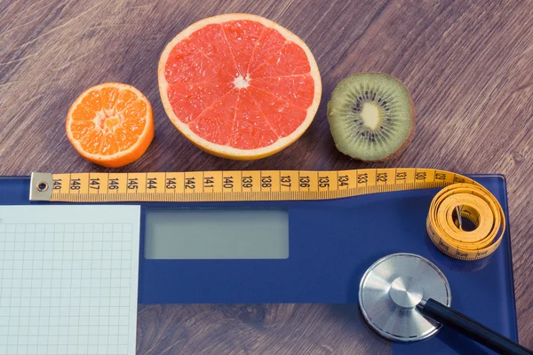 Elektroniska badrumsvåg, centimeter och färsk frukt med stetoskop, bantning och hälsosam livsstil — Stockfoto
