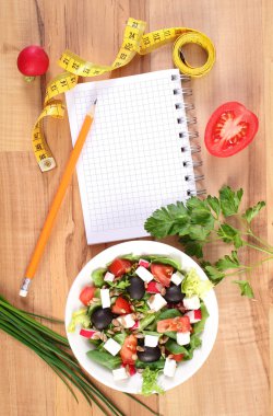 Taze Yunan salatası sebze, santimetre ve notlar, sağlıklı beslenme ve zayıflama kavramı yazmak için not defteri