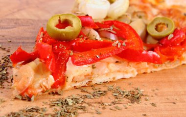 Slice of vegetarian pizza and seasoning on wooden surface