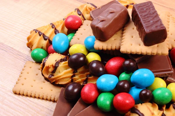 Una gran cantidad de dulces en la superficie de madera, alimentos poco saludables —  Fotos de Stock
