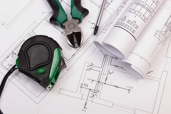 Las herramientas de trabajo y los rollos de los diagramas sobre la construcción el dibujo de la casa — Foto de Stock