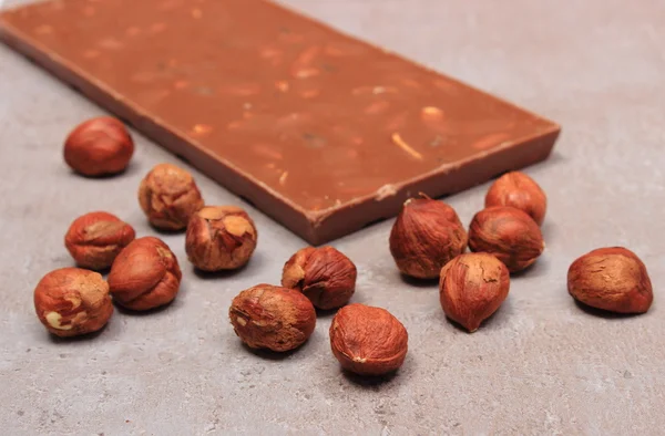 Chocolate nutritivo e avelãs na estrutura de cimento — Fotografia de Stock