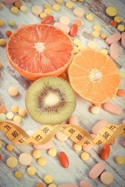 Vintage Fotoğraf, doğal meyve, santimetre ve tıbbi hapı, zayıflama, sağlıklı beslenme ve sağlık takviyeleri arasında seçim