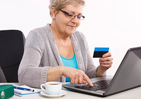 Ouderen senior vrouw met creditcard en laptop betalen via internet voor nutsbedrijven of online winkelen — Stockfoto