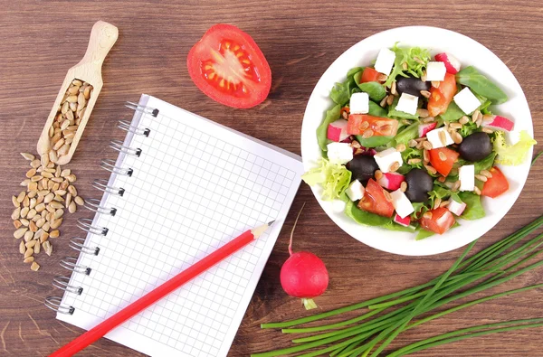 Fresh greek salad with vegetables and notepad for writing notes, healthy nutrition — Stock Photo, Image