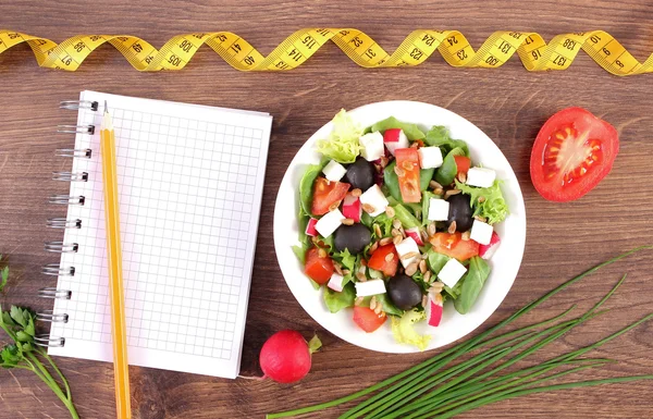 Insalata greca fresca con verdure, centimetro e blocco note per scrivere note, nutrizione sana e concetto di dimagrimento — Foto Stock