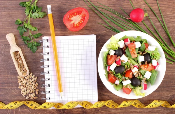 Insalata greca fresca con verdure, centimetro e blocco note per scrivere note, nutrizione sana e concetto di dimagrimento — Foto Stock