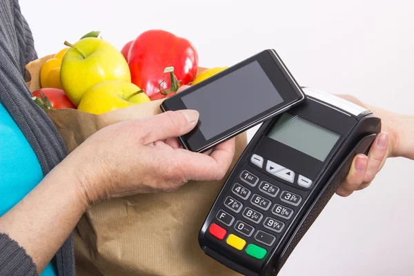 Рука женщины, использующей платежный терминал с мобильного телефона, оплачивающей покупки — стоковое фото