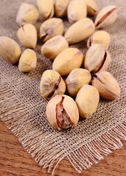 Pistacchi su tavolo di legno, alimentazione sana — Foto Stock