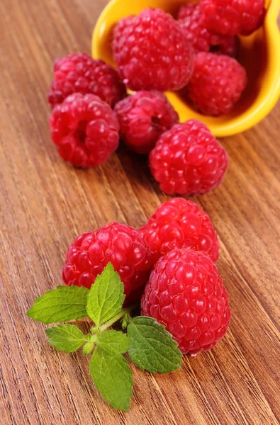 Fresh raspberries and lemon balm on wooden surface, healthy food — Stock Photo, Image