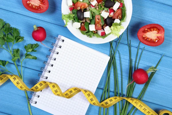 Греческий салат с овощами, сантиметр и блокнот для заметок, здоровое питание и концепция похудения — стоковое фото