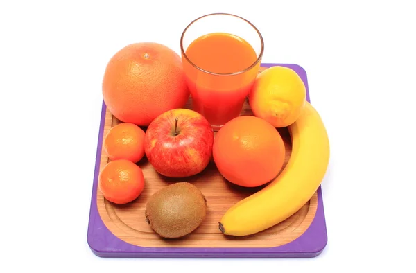Свежие натуральные фрукты и стакан сока на доске — стоковое фото