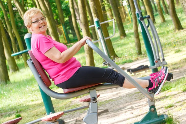 Senior Kvinna utövar övre och nedre kropp på utomhus gym, hälsosam livsstil — Stockfoto