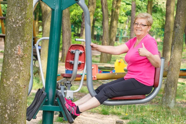 Senior Kvinna utövar lägre kropp på utomhus gym, hälsosam livsstil — Stockfoto