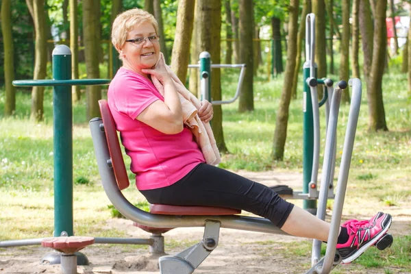 Senior Kvinna vilar efter träning på utomhus gym, hälsosam livsstil — Stockfoto