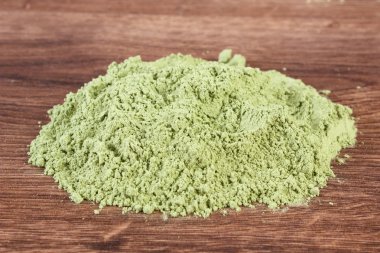 Ahşap arka plan üzerinde genç toz arpa yığını, vücut detoks