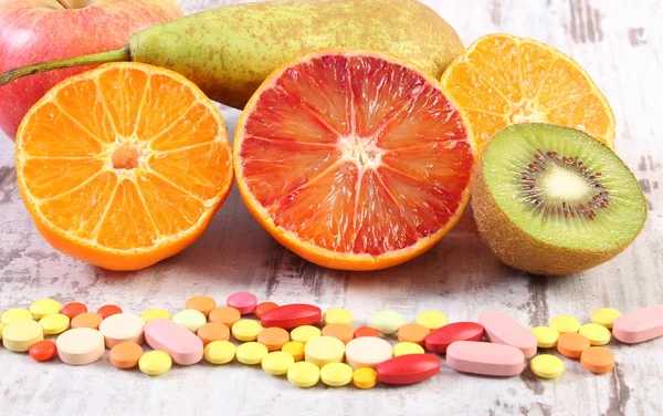 Natural fruits and pills, choice between healthy nutrition and supplements