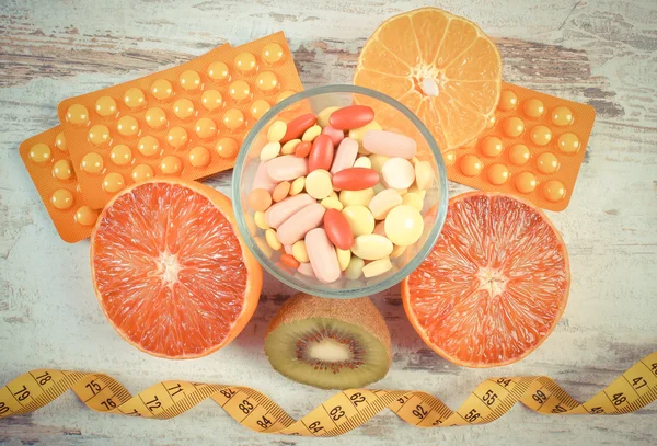 Foto vintage, Frutas naturales, centímetro y píldoras, adelgazamiento, elección entre la nutrición saludable y suplementos médicos —  Fotos de Stock