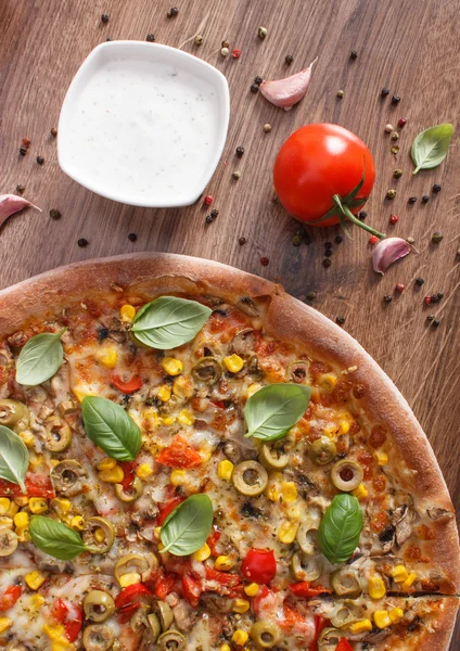 Vegetarische Pizza und Zutaten mit Gewürzen auf rustikalem Holzboden, Fast Food — Stockfoto