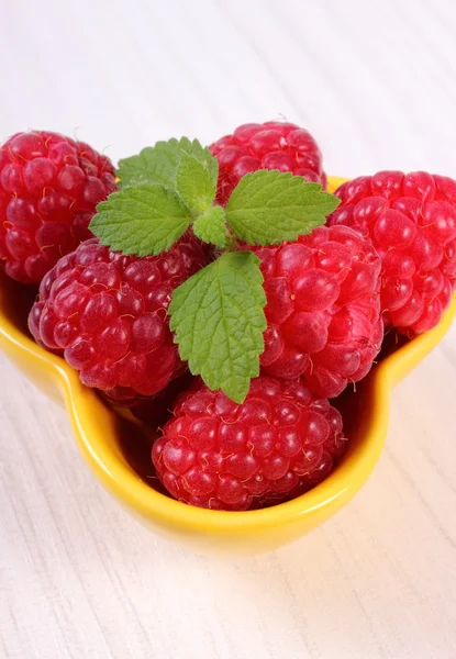 Fresh raspberries and lemon balm on white wooden table, healthy food — Stock Photo, Image