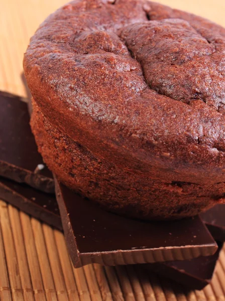 Gebakken muffins liggend op stukken van chocolade — Stockfoto