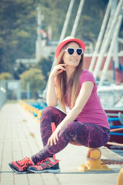 Mujer feliz con sombrero de paja y gafas de sol en el puerto con yate en el fondo, hora de verano — Foto de Stock