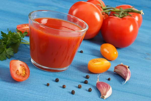 Tomatensap en groenten op een blauw bord, gezonde voeding — Stockfoto