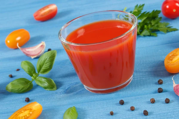 Tomatensap en fruit met specerijen op blauwe bord, gezonde voeding — Stockfoto