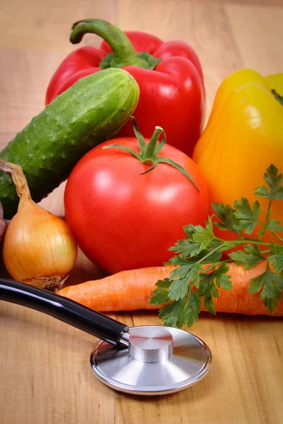 新鲜的蔬菜和听诊器木制表面、 健康的生活方式和营养 — 图库照片
