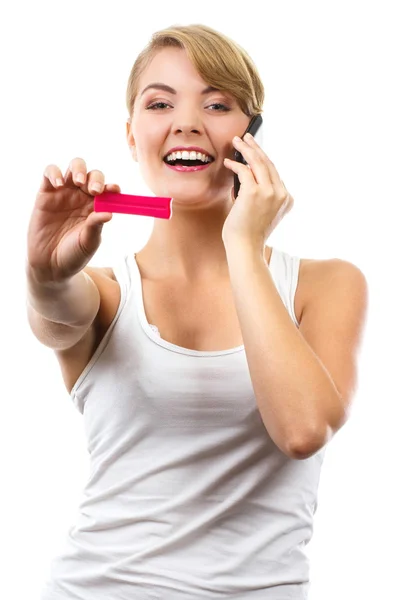 Щаслива жінка з телефоном інформує когось про позитивний тест на вагітність — стокове фото