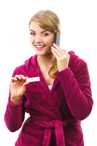 Happy woman with phone informing someone about positive pregnancy test