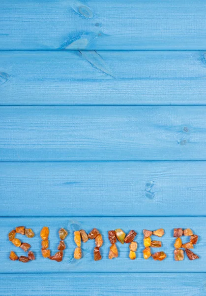 Palavra verão feito de pedras âmbar em placas azuis, hora de verão, espaço de cópia para texto — Fotografia de Stock