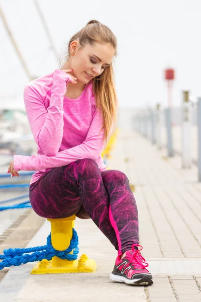 Nadenkend meisje in de sport dragen rust na de oefening in de zeehaven, gezonde en actieve levensstijl — Stockfoto