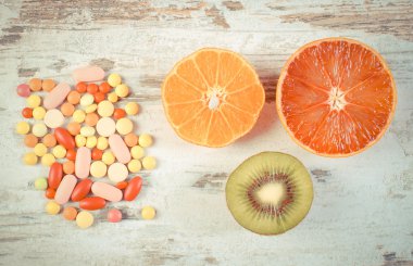Vintage fotoğraf, Taze meyve ve renkli tıbbi haplar, sağlıklı beslenme ve tıbbi takviyeleri arasında seçim