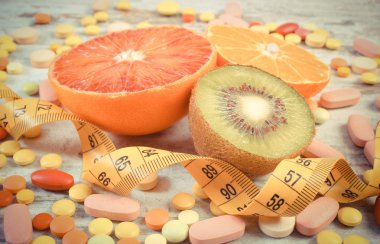 Vintage Fotoğraf, doğal meyve, santimetre ve tıbbi hapı, zayıflama, sağlıklı beslenme ve sağlık takviyeleri arasında seçim