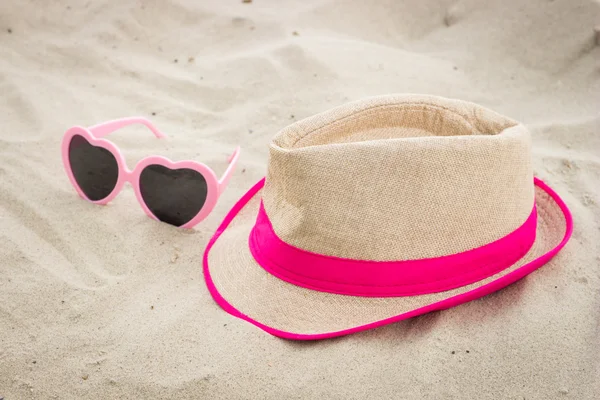 Óculos de sol e chapéu de palha na areia na praia, proteção solar, hora de verão — Fotografia de Stock