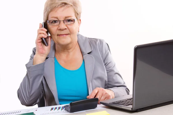 Ältere Geschäftsfrau, die am Handy telefoniert und am Schreibtisch arbeitet, Geschäftskonzept — Stockfoto