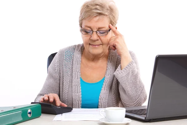 Пожилая женщина, считающая счета за коммунальные услуги дома, финансовое обеспечение в преклонном возрасте — стоковое фото
