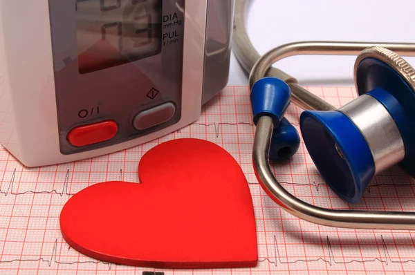 Stethoscope, heart shape, blood pressure monitor on electrocardiogram — Stock Photo, Image