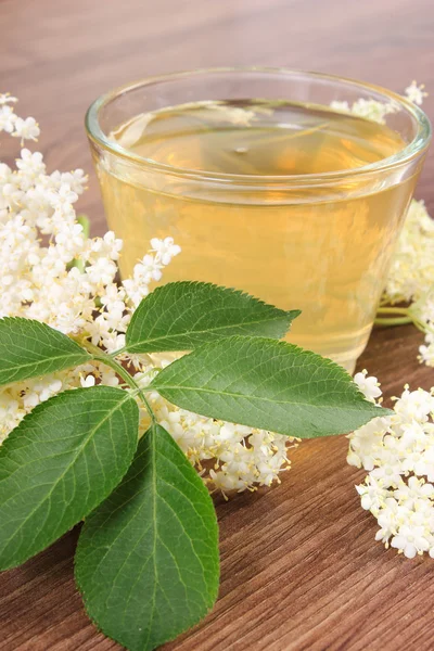 Fresco jugo sano y flores de saúco en tablero rústico — Foto de Stock