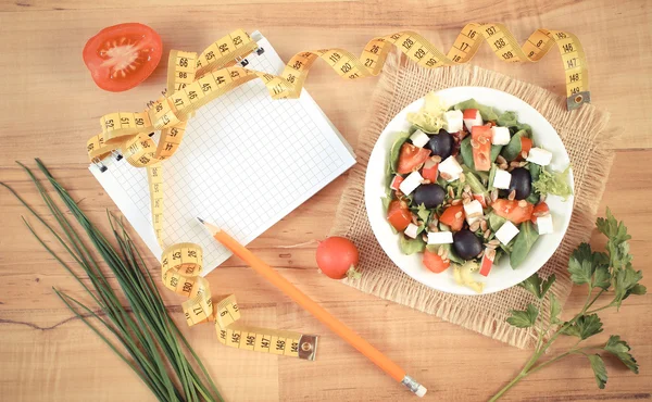 Foto d'epoca, insalata greca con verdure, centimetro e blocco note per note, nutrizione sana e concetto di dimagrimento — Foto Stock