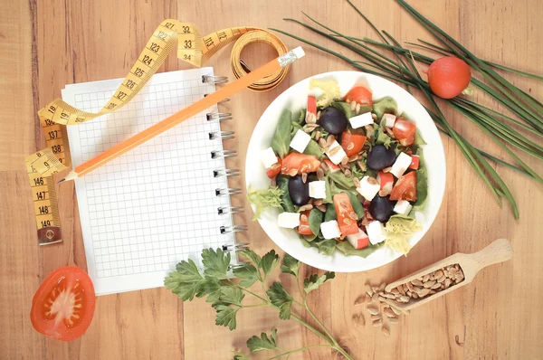 Archiwalne zdjęcie, sałatka grecka z warzyw, centymetr i Notatnik, notes, zdrowe odżywianie i odchudzanie koncepcja — Zdjęcie stockowe