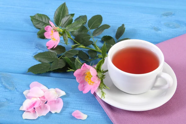 喝杯茶，野生玫瑰花卉蓝色板上 — 图库照片