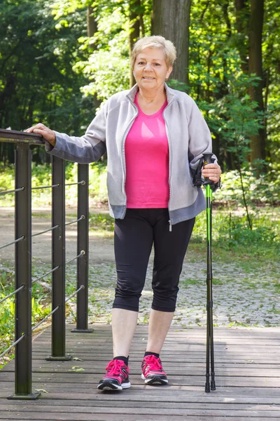 Idősek magas rangú nő gyakorló nordic walkingra, sportos életmód idős korban — Stock Fotó