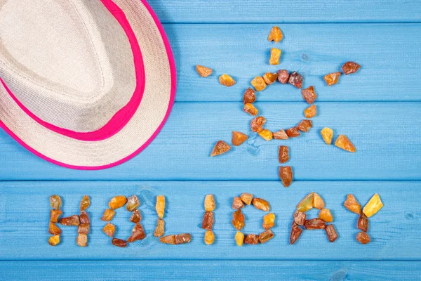 Word holiday and shape of sun, straw hat on blue boards, summer time — Stock Photo, Image