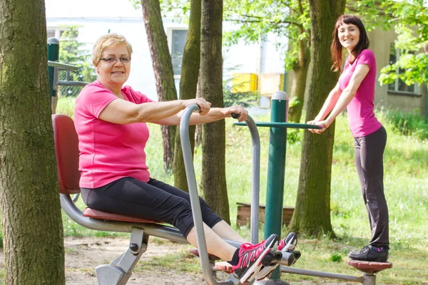 Vezető és gyakorló felső és alsó test, a kültéri edzőteremben, egészséges életmód, fiatal nő — Stock Fotó