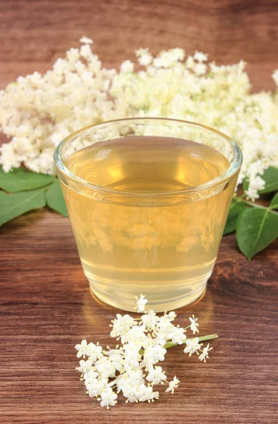 Fresco jugo sano y flores de saúco en tablero rústico — Foto de Stock