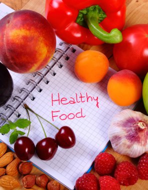 Fruits and vegetables with notebook, slimming and healthy food