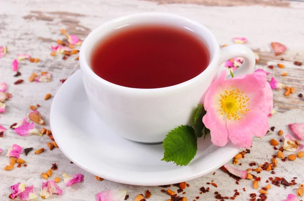喝杯茶与旧仿古木制背景上的野生玫瑰花朵 — 图库照片